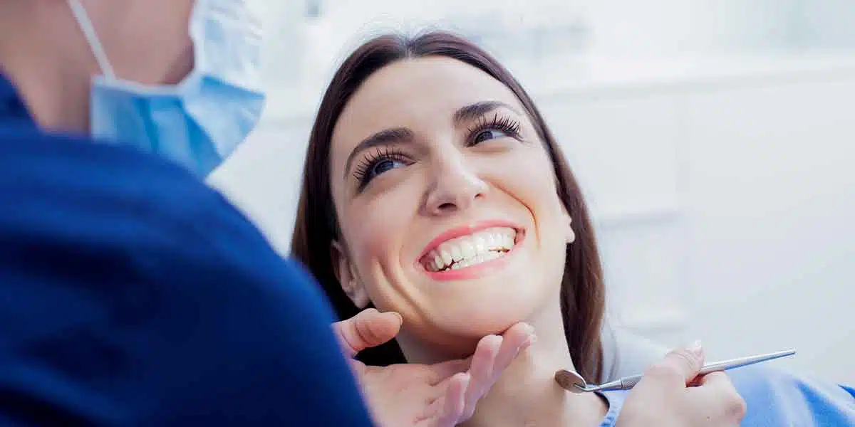 Young Woman Smiling as She Speaks to Dentist